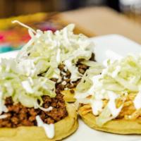 Sopes · Three small discs of fried corn dough, topped with re-fried beans, lettuce, sour cream, onio...