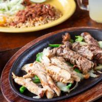 Combo Fajitas* · (Choose two) marinated chicken, steak or grilled shrimp served on a sizzling skillet with fr...