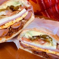 Torta Cubana · Served on a toasted bun topped with Mexican chorizo, fried egg, hotdog, ham, queso fresco, r...