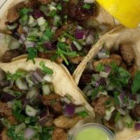 Al Pastor Taco · Pork served on two corn tortillas with cilantro and grilled onions.