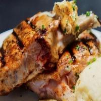 Pork Chop · Bone in pork chops grilled and topped with garlic butter, served with garlic mashed potatoes.