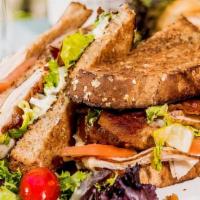 Turkey Club Sandwich · Sliced multi-grain, Swiss cheese, bacon, tomato, lettuce, and truffle aioli.