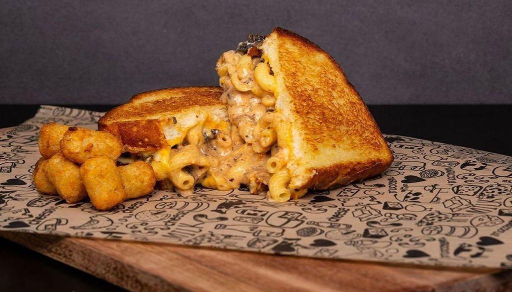 Best Of Both Worlds Grilled Cheese Sandwich  · A Baked Mac & Cheese Sandwich with Slow-Cooked Short Rib, White Cheddar Cheese, and American Cheese finished off with BBQ Sauce.
