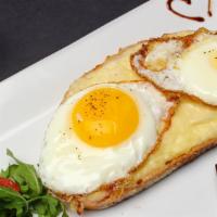 Croque Madame · A light spread of bechamel on toasted bread topped with cheese, ham, and a fried egg.