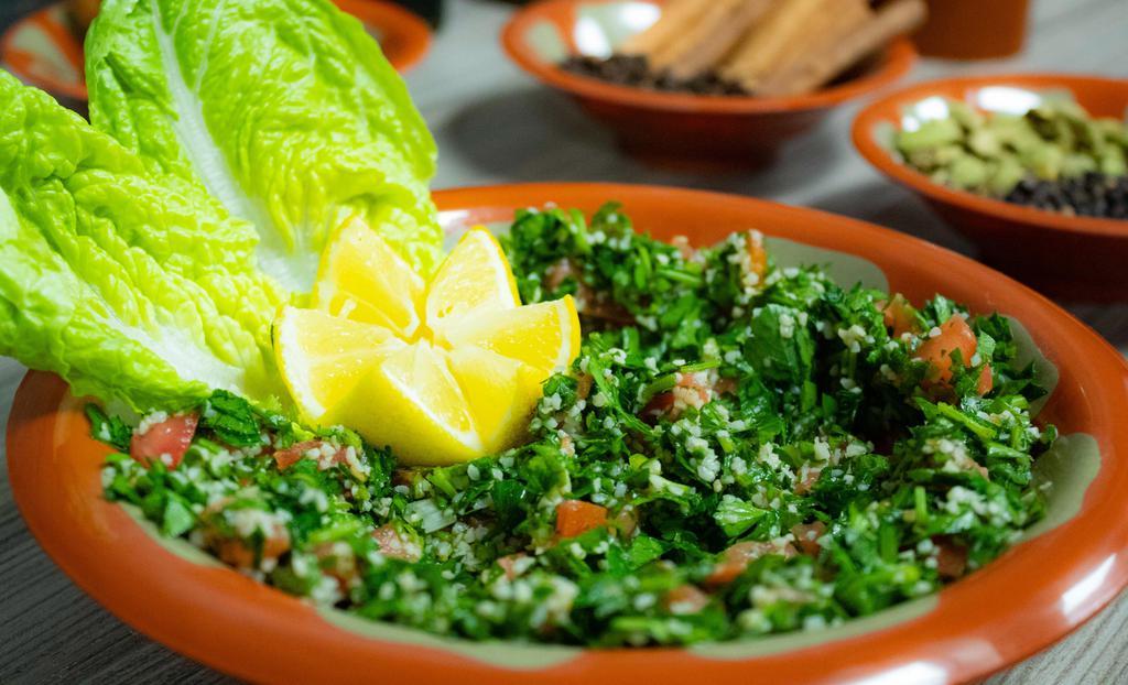 Tabbouleh Salad · Chopped parsley, bulgur wheat, tomatoes, onion, mixed with a minty blend of lemon, and extra virgin olive oil.