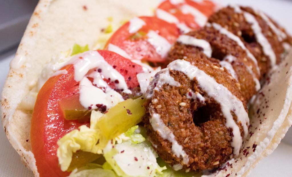 Falafel Sandwich · Falafel with lettuce, tomatoes, pickles and tahini sauce rolled in pita bread wrap.