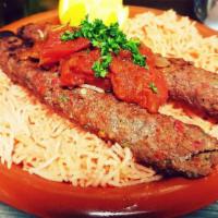 Adana Kabob Plate · Three skewers of Adana kabob charcoal grilled served over a bed of seasoned rice, 