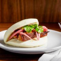Pork Belly Steamed Bun · Slow roasted local pork, pickled red onions, pecan sugar.