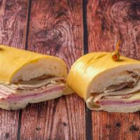 Sándwich Cubano / Cuban Sandwich · Jamón serrano, queso suizo, cerdo asado, encurtidos sobre pan cubano. / Serrano ham, Swiss c...