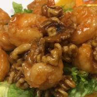 Crispy Walnut Shrimp · Lightly battered shrimp glazed in sweet house sauce, tossed with walnuts and served over let...