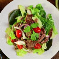 Beef Salad (Yum Neau) · Spicy. Marinated grilled beef, cucumbers, onions, tomatoes, cilantro, on bed of lettuce.