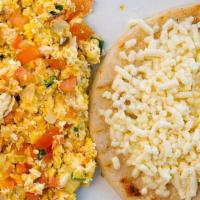 Huevos Pericos · Scrambled eggs, chopped onions, and tomatoes. Served with arepa paisa topped with white chee...
