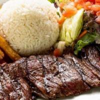 Carne Asada · Wood grilled sirloin steak 10 oz, marinated with spices. Served with white rice, French frie...