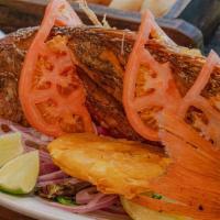 Mojarra · Whole deep fried tilapia fish. Served with white rice and fried green plantains.