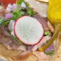 Carnitas Taco · Pork confit with caramelized onions on a soft corn tortilla, topped with onions and cilantro.