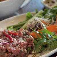 Beef Tartare Thai Style · Minced beef served raw with basil, lime juice, rice powder & chilis