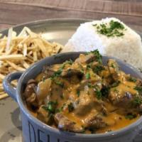 Beef Strogonofe · delicious creamy sauce with strips of filet and mushrooms. Served with white rice and stick ...