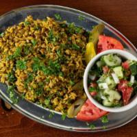 Mjaddara · Vegan. A rice dish consisting of lentils and topped with Arabic salad.