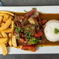 Lomo Saltado · Steak strips sautéed with onions, tomatoes and cilantro in a wine and soy sauce served with ...