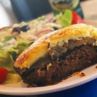 Mousaka · Casserole with layers of ground beef, eggplant, potatoes, and topped with bechamel. Served w...