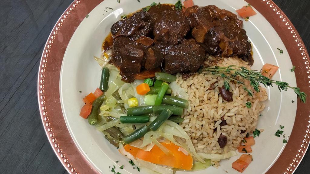Oxtail · Short pieces of beef from the part of the tail, stewed in rich seasoning brown gravy, with butter beans. Served with rice & peas, steamed vegetables.