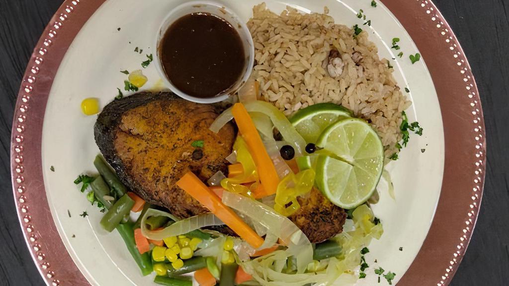 Escovitch King Fish · Fish pan fried and served with onion, carrot, all spice and vinegar sauce.  Served with rice & peas, steamed vegetables.