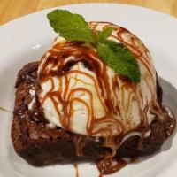 Chocolate Brownie Cake · Warm chocolate brownie cake with a scoop of vanilla ice cream topped with caramel fudge.