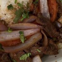 Lomo Saltado · Beef strips sauteed with onions and tomatoes. Served with French fries and rice.