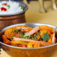 Kadai Chicken · Cooked in a stir-fry of colored bell peppers and onions in a tomato sauce.