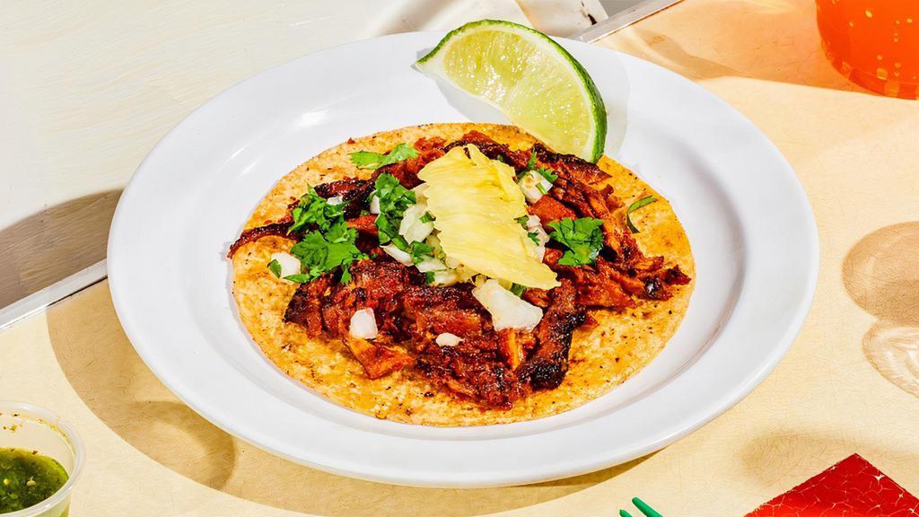 Al Pastor Taco. · Pasture-raised certified Berkshire pork, thinly sliced and marinated in a special chilies and spices marinade, slow-roasted on a trompo. The meat is then sliced off as it is cooked and topped with cilantro, diced onions and pineapple.