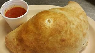 Calzone · Ricotta, Mozzarella, and ham all wrapped in pizza dough and baked to perfection.