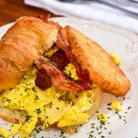 American Croissant · New. Three scrambled eggs, croissant, cheese, bacon, sausages, hash browns.