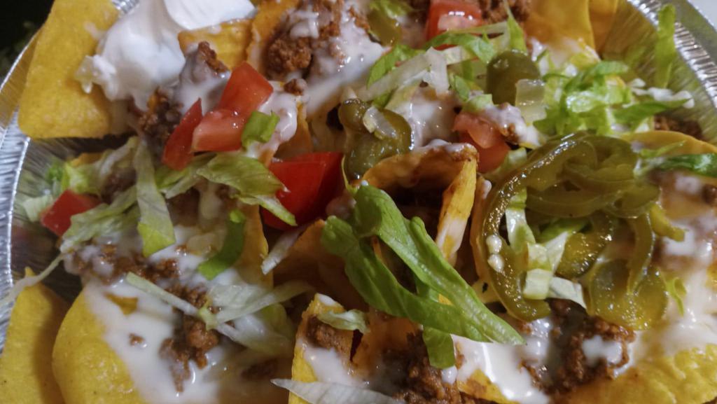Nachos With Beef · Tortillas chips, lettuce, tomato, sour cream, jalapeño, beans, cheese.