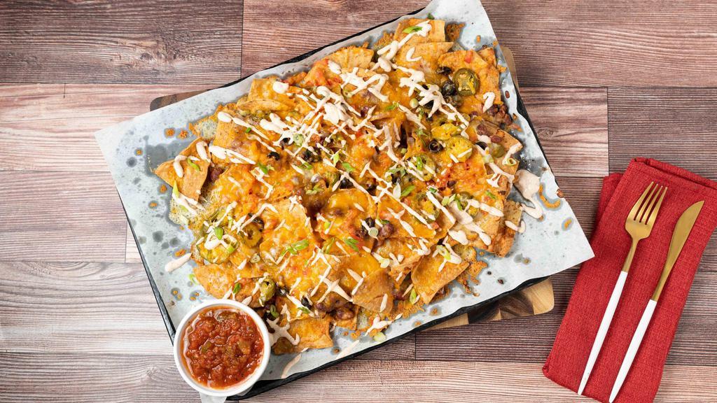 Brewery Nachos · Corn tortilla chips piled with red beans, black olives, tomatoes jalapeños, pepper jack and cheddar cheeses, finished with chili lime sour cream.