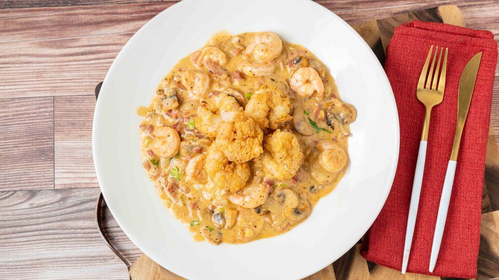 Shrimp & Grits · Sautéed shrimp with bacon, garlic mushrooms and scallions over cheddar and pepper jack grits, finished with fried royal red shrimp.