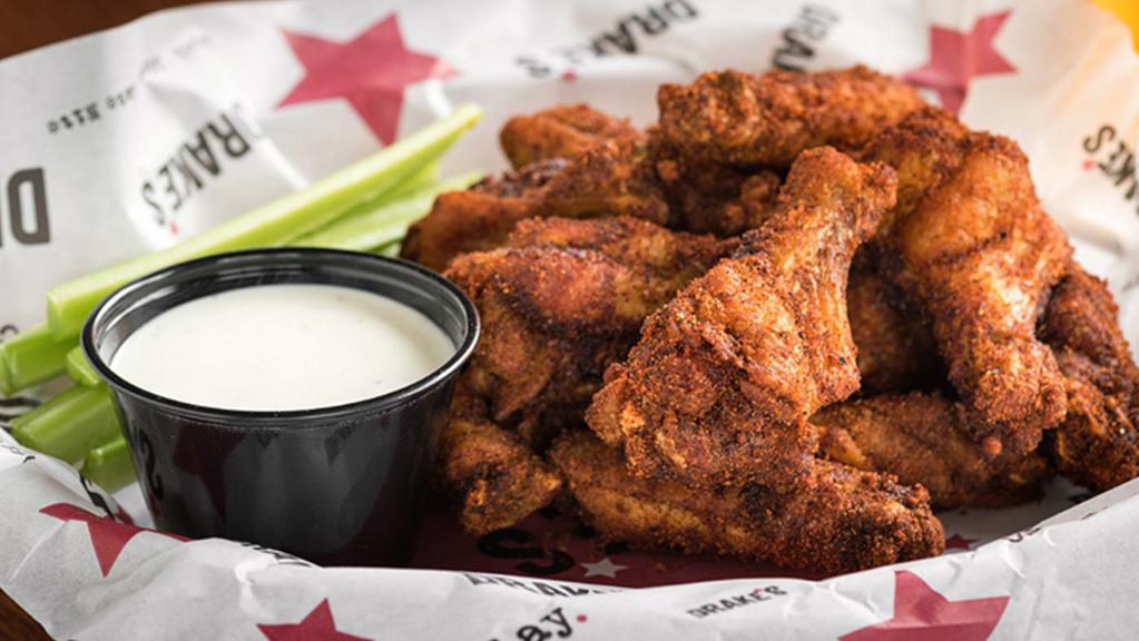 Sriracha Wings · Crisp and zesty sriracha dry rub wings, juicy on the inside and packed with flavor; served with celery and your choice of ranch or blue cheese.