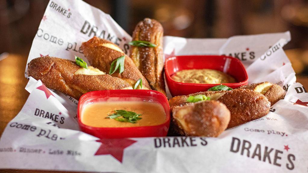 Warm Pretzels & Beer Cheese · Soft, warm pretzel bites with house mustard and beer cheese dip made from sharp cheddar cheese, spices and American amber ale.