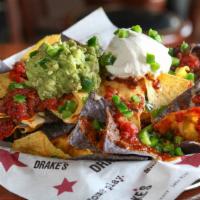 Drake'S Nachos · Fresh tortilla chips layered with beef and bean chili and warm beer cheese, topped with fire...