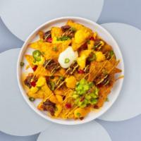 Chili & Cheese Nachos · Salted tortilla chips doused in tomatoes, queso cheese and jalapeño peppers.