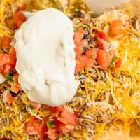 Nachos · Tortilla chips smothered in a combination of cheddar nacho and queso Blanco cheese, beans an...