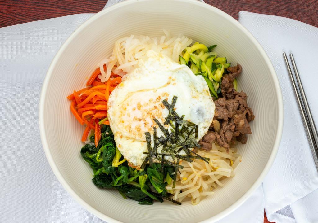 Bibimbap · Spicy. Rice with seasonal vegetables, beef, and topped with sunny side up egg. Comes with sauce on the side and Served with two Daily side dishes include kimchi and one side dish of the day.