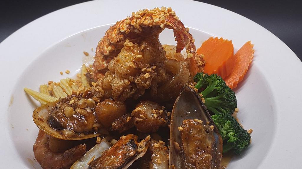 Garlic Seafood · Lightly battered then sauteed in garlic, black pepper with shrimp, half lobster tail, scallop, mussel and squid served on a bed of steamed mixed vegetables.