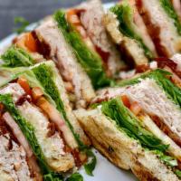 Turkey Club · Roasted Turkey, Crispy Bacon, Lettuce, Tomato, and Mayo stacked between three layers of Toas...