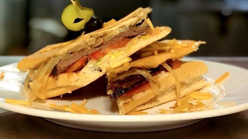 Pan Con Bistec · Our famous Grilled Steak sandwich, served in toasted Cuban bread with Grilled onions, lettuce and tomatoes topped off with potato sticks
