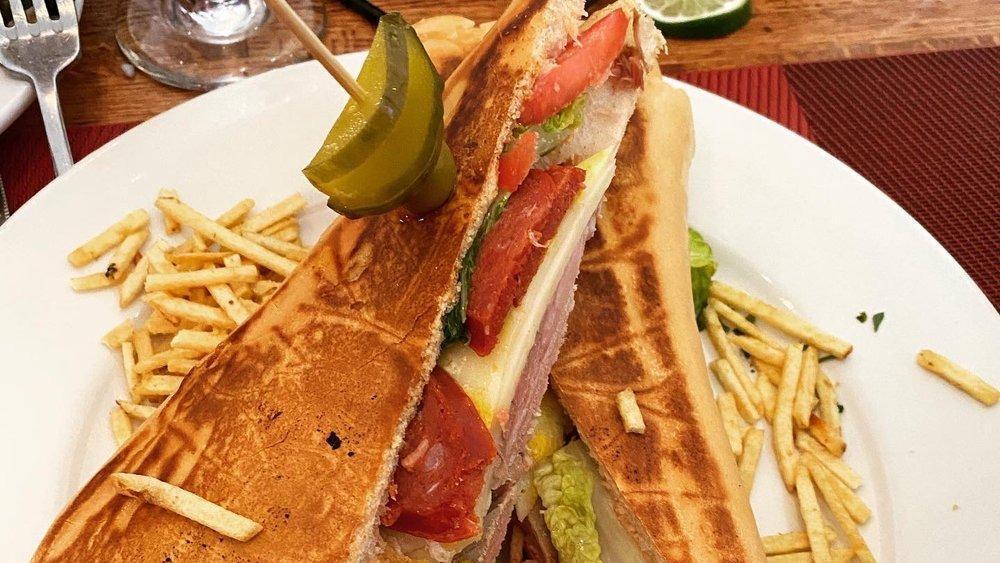 Sandwich Cubano · Classic Cuban Sandwich made with Ham, Pork, Swiss cheese, pickles and a touch of mustard on Cuban bread