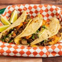 Angus Steak Taco · Grilled steak in a corn tortilla with avocado sauce and onions and cilantro.