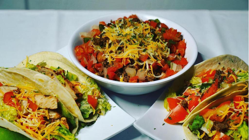Tacos · Two grilled flour tortillas stuffed with cheese, lettuce, tomatoes, salsa, and sour cream.