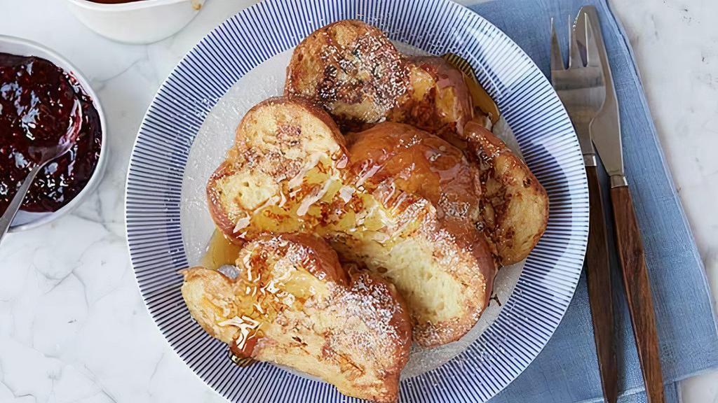 Challah French Toast · Thick sliced challah bread dipped in egg wash and pan fried. Accompanied with pecan wood smoked bacon or seasonal fruits and berries.