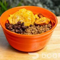 The Complete Bowl · A bowl with rice, beans, Impossible beef, and sweet plantains. Tostones available if in stock.