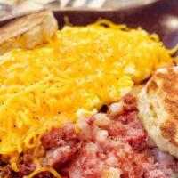 Corned Beef Hash Skillet · Three eggs and a hearty helping of corned beef hash with cheese, served over home fried pota...